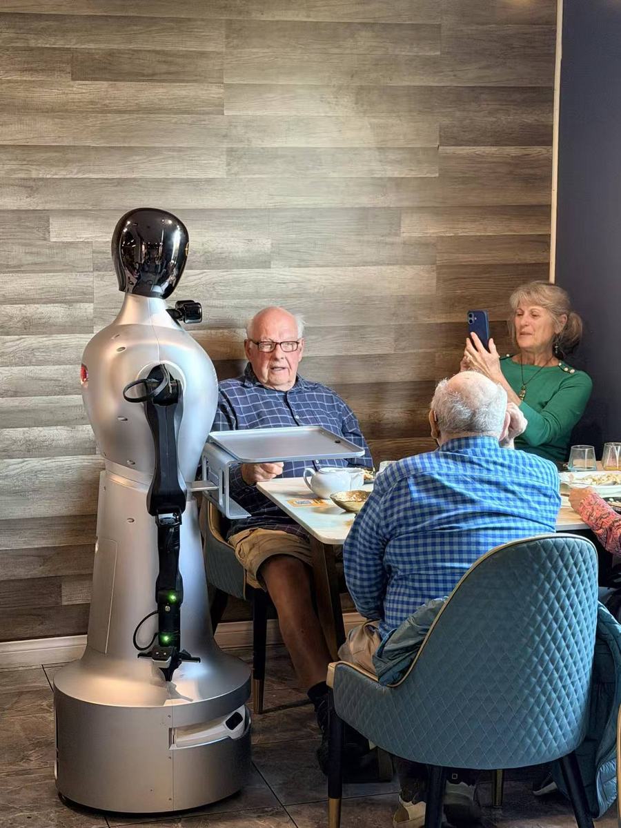 StarBot Nova delivering a tray to a table of seated guests
